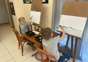 Dzieci malują przy sztalugach